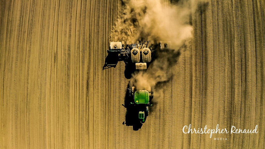 Aerial drone view of a farmer plowing land in Agassiz BC, captured by Chris R Media, depicting the beauty and dedication in agriculture.